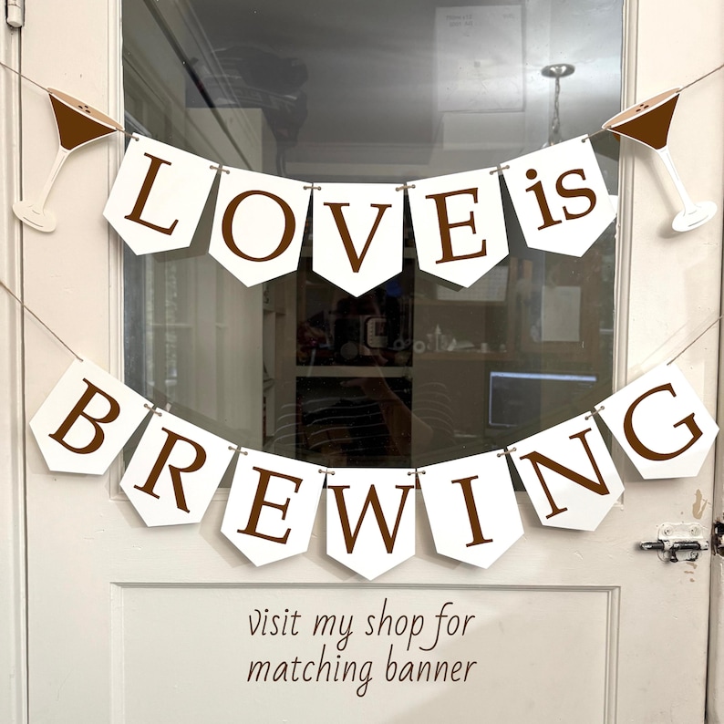 May include: White banner with brown lettering that reads "LOVE is BREWING". The banner is decorated with martini glass cutouts. The text "visit my shop for matching banner" is below the banner.