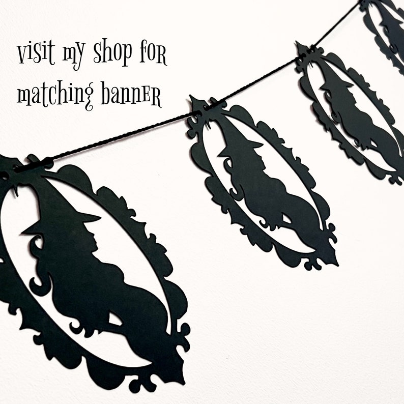 Puede incluir: Bandera de papel negro con una silueta de una bruja en un marco decorativo. La bandera est&aacute; enhebrada con hilo negro. El texto "visit my shop for matching banner" es visible en la imagen.