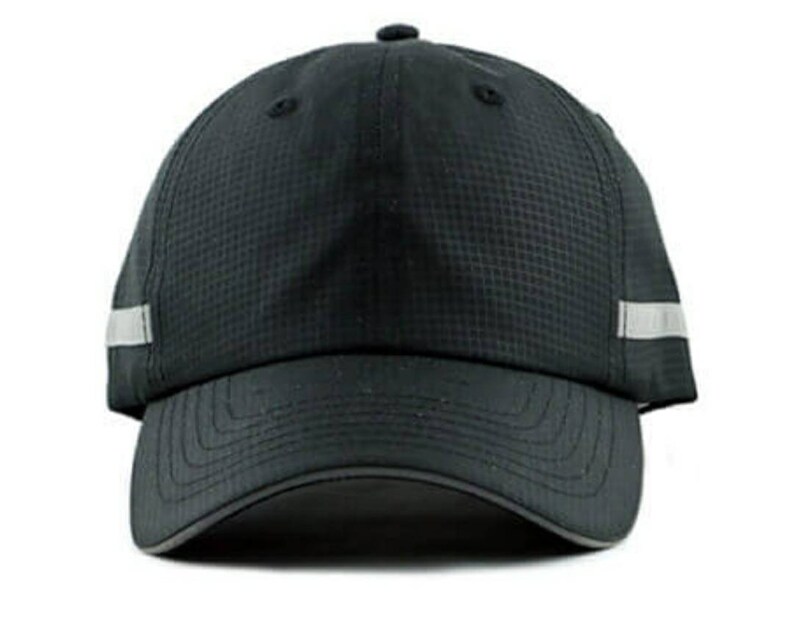May include: A black baseball cap with a reflective silver stripe on the side. The cap has a curved brim and a mesh back.