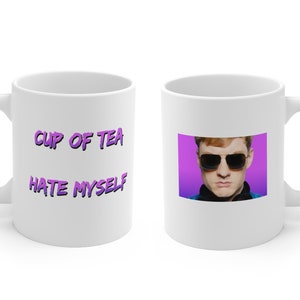 Könnte beinhalten: Weiße Keramiktasse mit dem Text "CUP OF TEA HATE MYSELF" in Lila auf der einen Seite und einem Foto eines Mannes mit roten Haaren, der eine Sonnenbrille trägt, auf einem lila Hintergrund auf der anderen Seite.