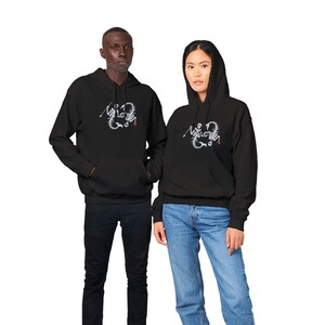 May include: Two people wearing black hoodies with a white skeleton scorpion graphic on the front. The hoodie has a drawstring hood and a kangaroo pocket.