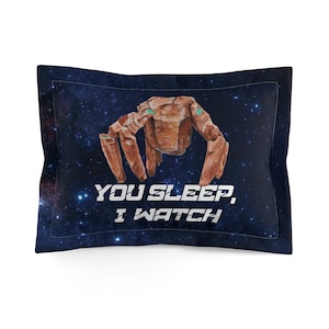 May include: A rectangular pillowcase with a dark blue background featuring a space-like design. The pillowcase has a brown, tree-like figure in the center with the text "YOU SLEEP, I WATCH" in white.