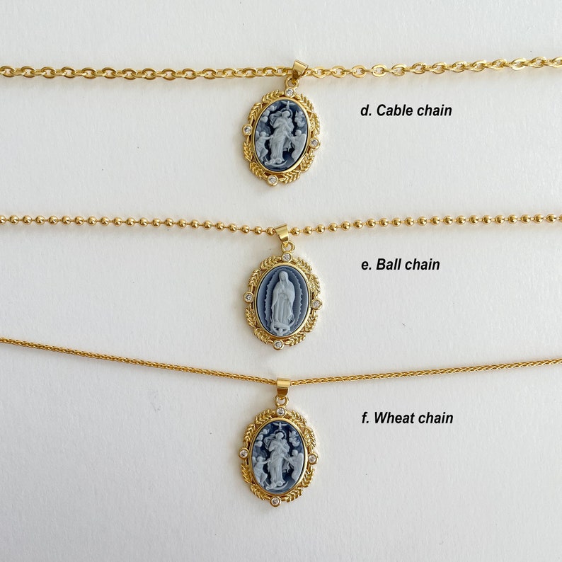May include: Three gold necklaces with different chain styles: cable, ball, and wheat. Each necklace features a pendant with a blue and white cameo image.