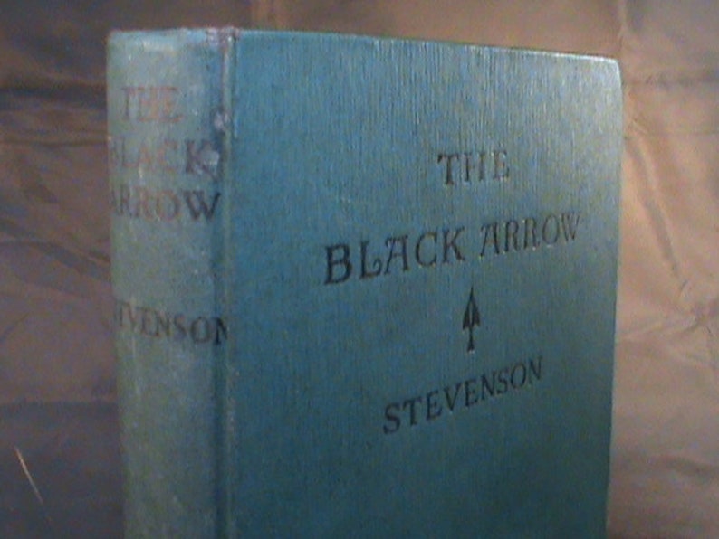 May include: A blue hardback book with the title "The Black Arrow" and the author's name "Stevenson" on the cover.