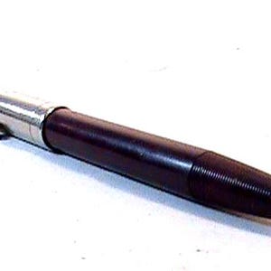 May include: A dark brown pen with a silver metal clip and tip. The pen has a sleek design with a smooth, dark brown barrel and a silver metal cap. The pen is designed for writing.