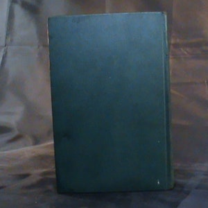 May include: A dark green hardback book with no visible title or author.