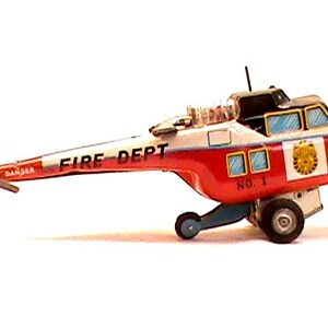 Pode incluir: Um helicóptero de brinquedo vintage em vermelho, branco e azul. As palavras "FIRE DEPT" estão impressas na lateral do helicóptero. O brinquedo tem uma hélice, rodas e uma pequena antena.