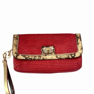 Op de afbeelding: Rode geweven clutch met een gouden kettingband en een slangenleren rand. De clutch heeft een gouden sluiting en gouden studs.