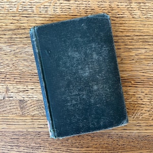 May include: A dark blue hardcover book with a worn, textured cover.