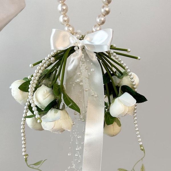 Ramo de novia clásico de rosas blancas con mango de perlas.