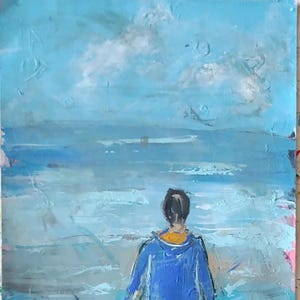K&ouml;nnte beinhalten: Ein &Ouml;lgem&auml;lde auf Leinwand, das eine Person von hinten zeigt, die eine leuchtend blaue Kapuzenjacke tr&auml;gt und vor einer strukturierten, abstrakten Meereslandschaft steht. Das Bild zeigt Schattierungen von Hellblau, Wei&szlig; und Grau.