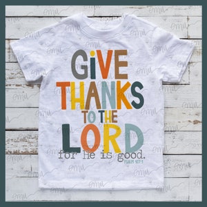 K&ouml;nnte beinhalten: Wei&szlig;es T-Shirt mit einem bunten Grafikdesign, auf dem "Give Thanks to the Lord for He is good. Psalm 107:1" steht.