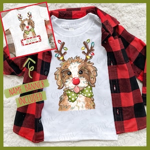 Puede incluir: Camiseta blanca con un perro de dibujos animados con cuernos de reno, una nariz roja y una pajarita verde con lunares. También se ve una camisa de franela a cuadros rojos y negros. La imagen incluye una pancarta que dice "NAME BANNER INCLUDED".