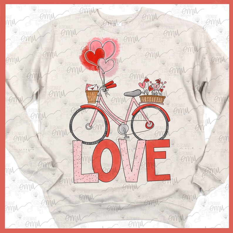 Pu&ograve; includere: Una felpa bianca con una bicicletta rosa e rossa con un cestino di fiori e un cestino di posta. La bicicletta &egrave; sopra la parola "LOVE" in lettere rosa e rosse.