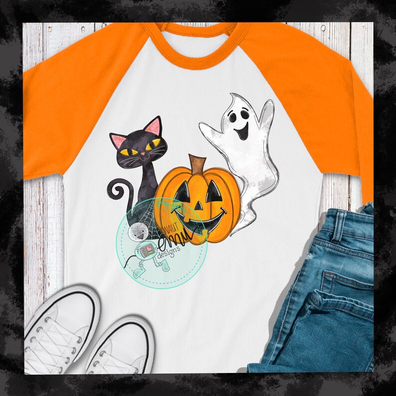 May include: A white t-shirt with an orange raglan sleeve design. The t-shirt features a black cat, a smiling jack-o'-lantern, and a white ghost. The design is in a watercolor style.