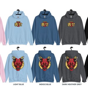 May include: A set of ten hooded sweatshirts in various colors, including light pink, light blue, indigo blue, dark heather grey, and black. The front of each sweatshirt features the Japanese word "表せ" in gold lettering. The back of each sweatshirt features a red Japanese demon mask with gold horns and a yellow background.