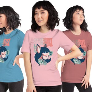 Peut inclure: Trois femmes portant des t-shirts avec un dessin de renard de bande dessin&eacute;e portant un masque. Les chemises sont en bleu, rose et rouge.