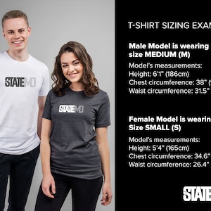 May include: Two models wearing t-shirts with the logo "STATEMO" printed on the front. The male model is wearing a white t-shirt and the female model is wearing a grey t-shirt. The text "T-SHIRT SIZING EXAMPLE" is displayed above the models. The male model is wearing a size Medium (M) and the female model is wearing a size Small (S). The models' measurements are listed below their respective images.