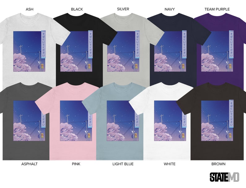 May include: A collection of t-shirts featuring a graphic of a cityscape at night with Japanese text that reads "そばにいてください" which translates to "Please be by my side". The t-shirts are available in a variety of colours, including ash, black, silver, navy, team purple, asphalt, pink, light blue, white, and brown.