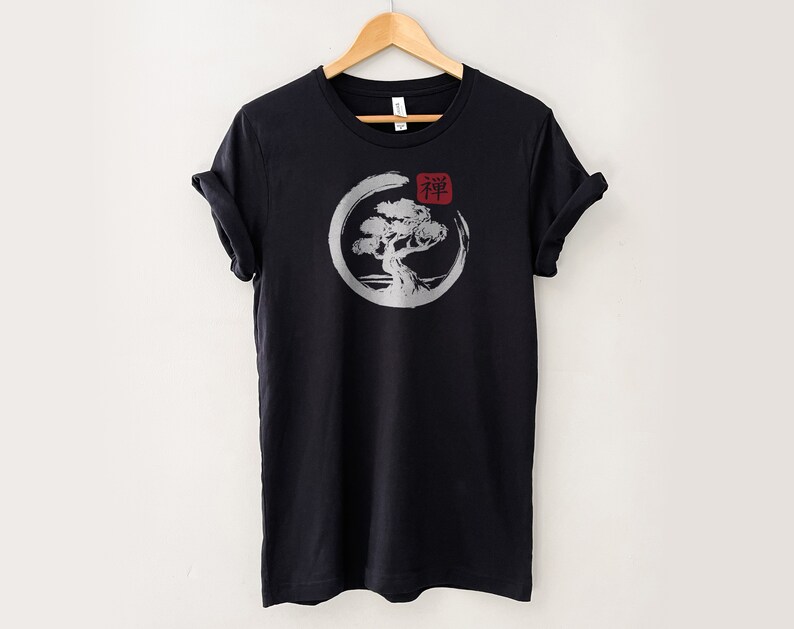 Puede incluir: Camiseta negra con un gr&aacute;fico blanco de un &aacute;rbol en un c&iacute;rculo con la palabra japonesa "Zen" en rojo.