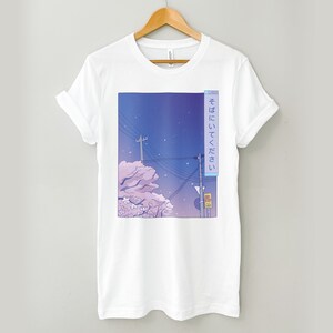 May include: White t-shirt featuring a graphic print of a cityscape at night with cherry blossoms and the Japanese text "そこにいてください" which translates to "Stay there".
