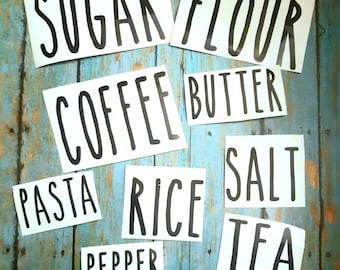 May include: White labels with black text for kitchen organization. The labels read: Sugar, Flour, Coffee, Butter, Pasta, Rice, Salt, Tea, and Pepper.