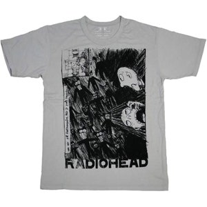May include: A light gray t-shirt featuring a black and white graphic design. The graphic includes a stylized illustration with the band name "RADIOHEAD" at the bottom. The shirt also has text that reads "we are not superheroes, this is really happening."
