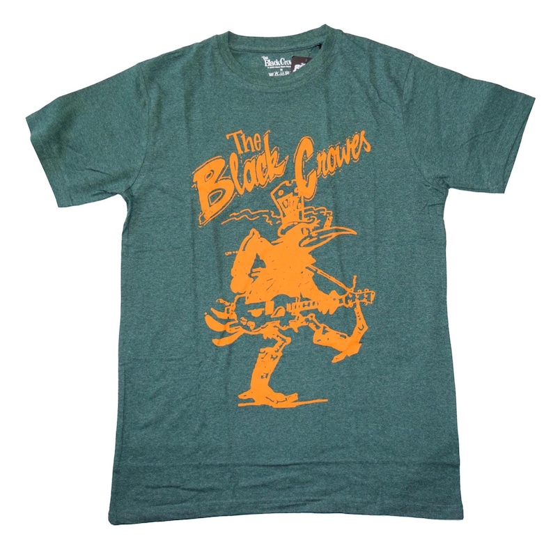 May include: Green t-shirt with the text "The Black Crowes" in orange, along with an orange illustration of a musician playing a guitar. The shirt is made of a soft material and has a crew neck.