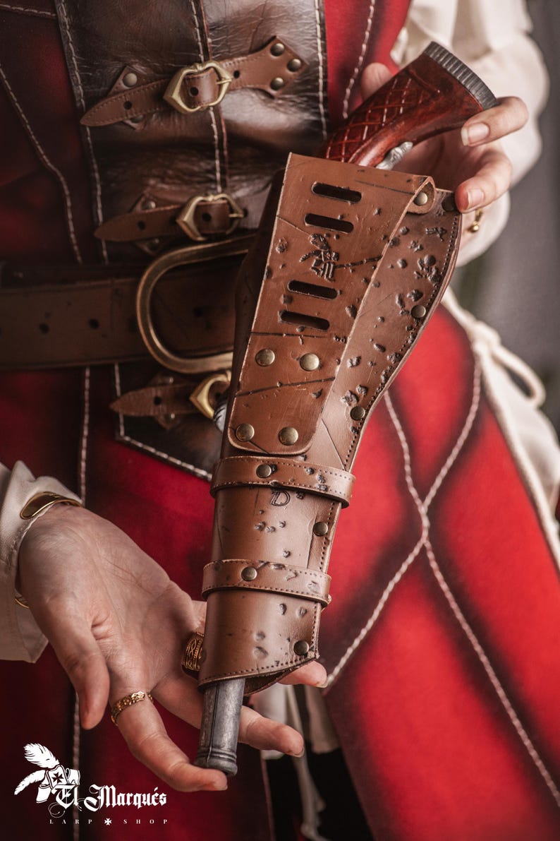 Puede incluir: Una funda de cuero marr&oacute;n con una hebilla de metal y un dise&ntilde;o decorativo. La funda contiene una peque&ntilde;a pistola de madera marr&oacute;n.
