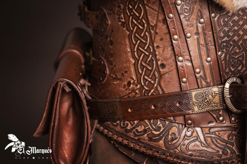 May include: A brown leather corset with intricate knotwork and metal accents. The corset has a belt with a decorative buckle and a small leather pouch attached to the side.