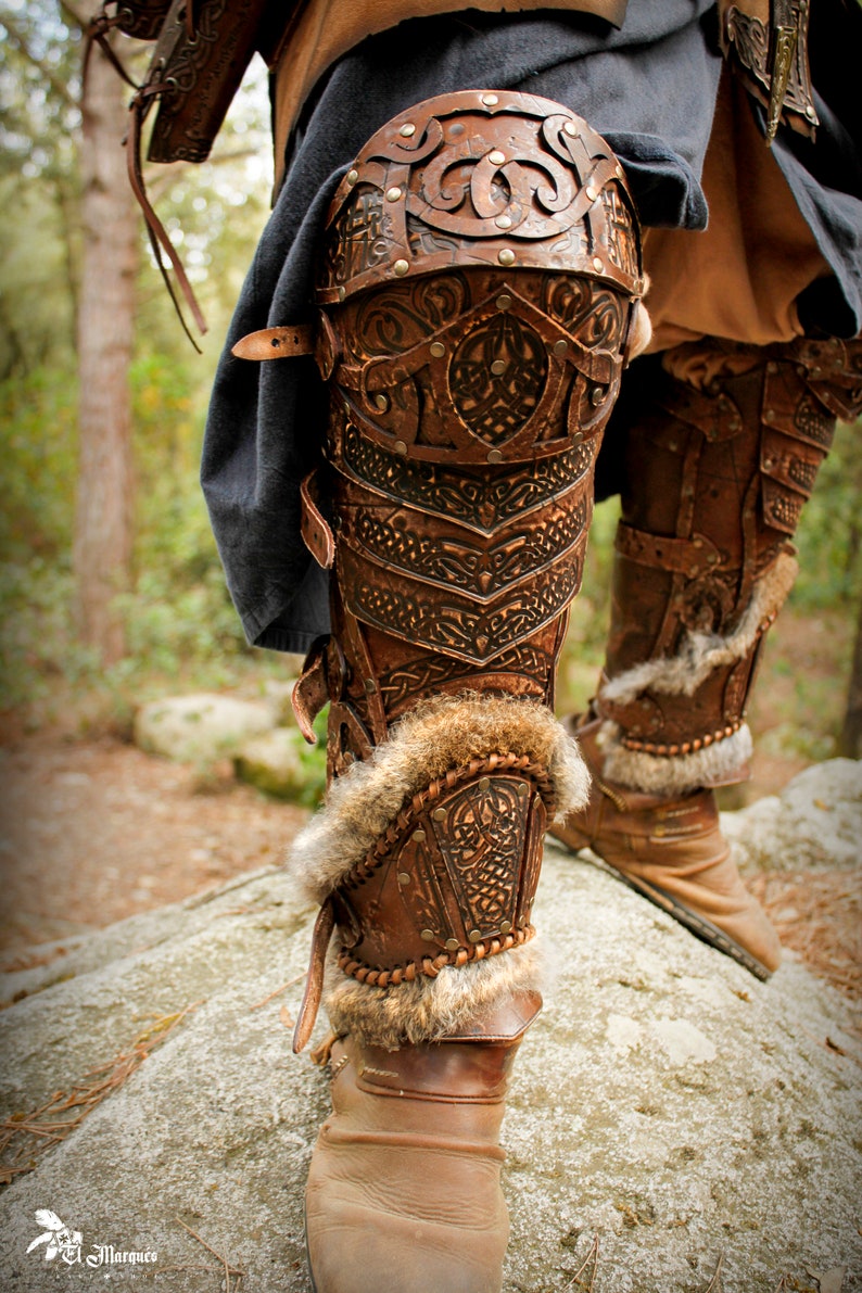May include: Close-up of a pair of brown leather knee-high boots with intricate designs and fur trim. The boots are worn and have a rustic look.