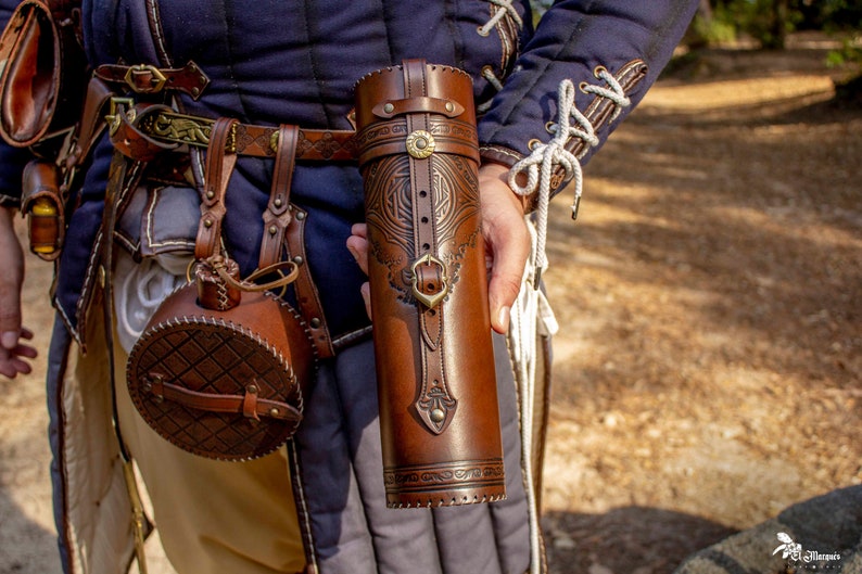 Peut inclure: Un carquois en cuir brun avec des sculptures complexes et des accents en laiton. Le carquois a une sangle et une fermeture &agrave; boucle.