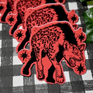 May include: A set of four red and black hyena stickers with a star design. The hyenas are depicted in a snarling pose.