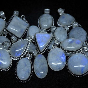 May include: A collection of silver pendants with moonstone gemstones. The pendants are in various shapes, including oval, square, and triangular. The moonstone is a milky white color with a blue iridescent sheen.
