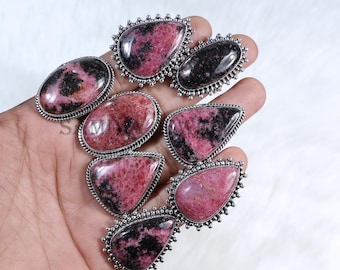 Pode incluir: Oito anéis de prata com engastes de pedras preciosas rosa e pretas. Os anéis apresentam uma variedade de designs, incluindo uma forma de lágrima e uma forma redonda.