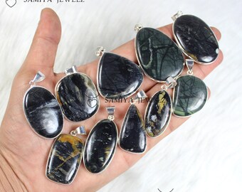 May include: A selection of gemstone pendants in diverse forms, such as oval, teardrop, and rectangular. The pendants display dark hues with silver-coloured metal settings. The brand name "SAMIYA JEWELZ" is visible in the image.