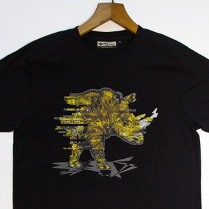 May include: Black t-shirt with a yellow and white graphic of a rhinoceros. The rhinoceros is depicted in a pixelated style.