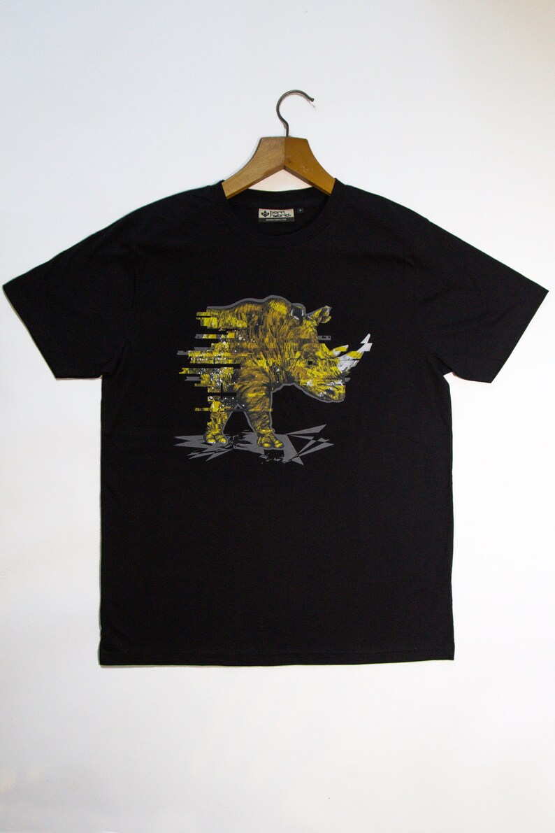 May include: Black t-shirt with a yellow and white graphic of a rhinoceros. The rhinoceros is depicted in a pixelated style.