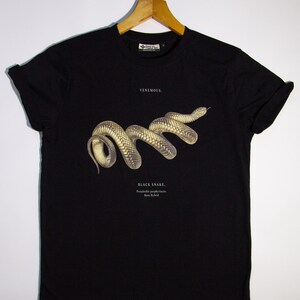 May include: Black t-shirt featuring a graphic of a black snake with the text "VENEMOUS." and "BLACK SNAKE.  Pseudechis porphyriticus.  Brown Hybrid."