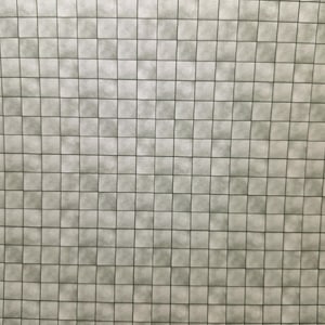 May include: A close-up of a white tiled wall with a grid pattern. The tiles are slightly textured and have a subtle sheen.