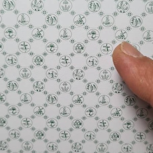 May include: A white background with a repeating pattern of green circles. Each circle contains a different design, including a windmill, a flower, a bird, and a house. The pattern is symmetrical and creates a visually appealing design.
