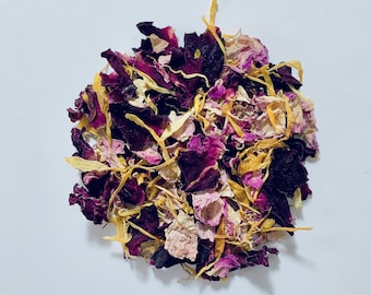 May include: A close-up of a pile of dried rose petals and yellow flower petals. The petals are a mix of pink, purple, and yellow.