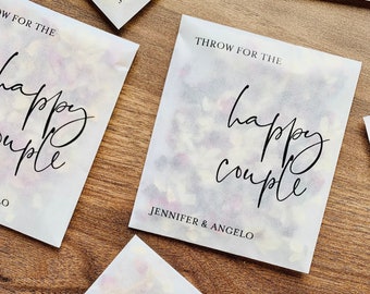 May include: White paper bags filled with confetti, with the text "Throw for the happy couple" and the names "Jennifer & Angelo" printed on them.
