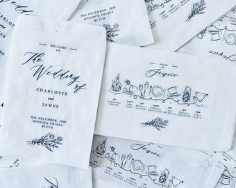 May include: A white wedding invitation with black calligraphy text and illustrations. The text reads "The Wedding of Charlotte and James" and includes the date, location, and time of the ceremony. The illustrations include a church, a heart, a camera, a top hat, and a plate with a fork and knife.