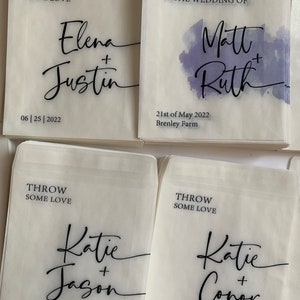 May include: Four white paper bags with black text. Each bag has a different wedding couple's names and wedding date. The text on the bags reads "Throw some love".