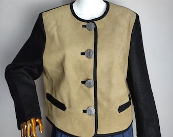 May include: A tan suede jacket with black fabric sleeves and black trim. The jacket has five silver buttons down the front.