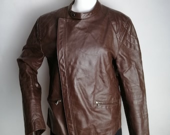 Könnte beinhalten: Eine braune Lederjacke mit Reißverschluss und mehreren Taschen.