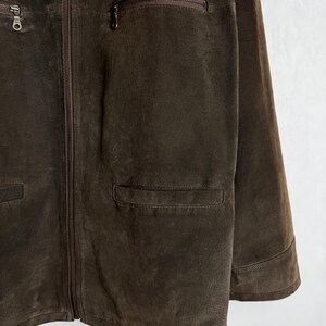 May include: A brown suede jacket with a zipper closure and multiple pockets.