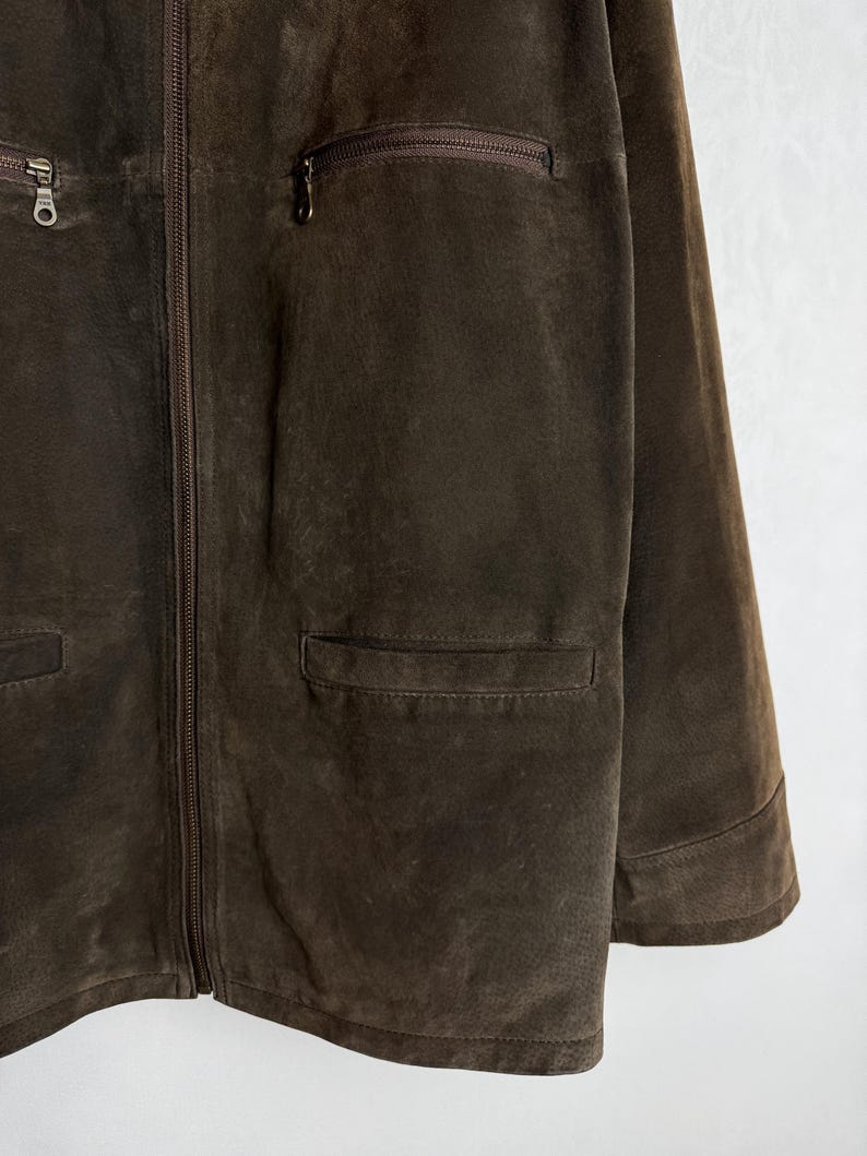 May include: A brown suede jacket with a zipper closure and multiple pockets.