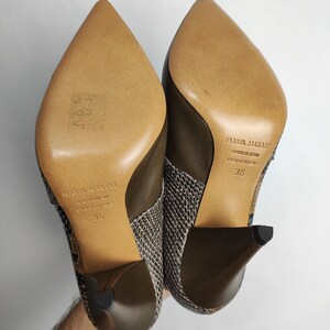May include: A pair of brown and black snakeskin heeled boots with a pointed toe. The boots are made by Isabel Marant and are size 36.